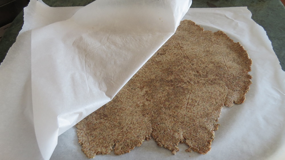 Odlijepite gornji papir za pečenje sa razvaljane ploče krekera od sjemenki
